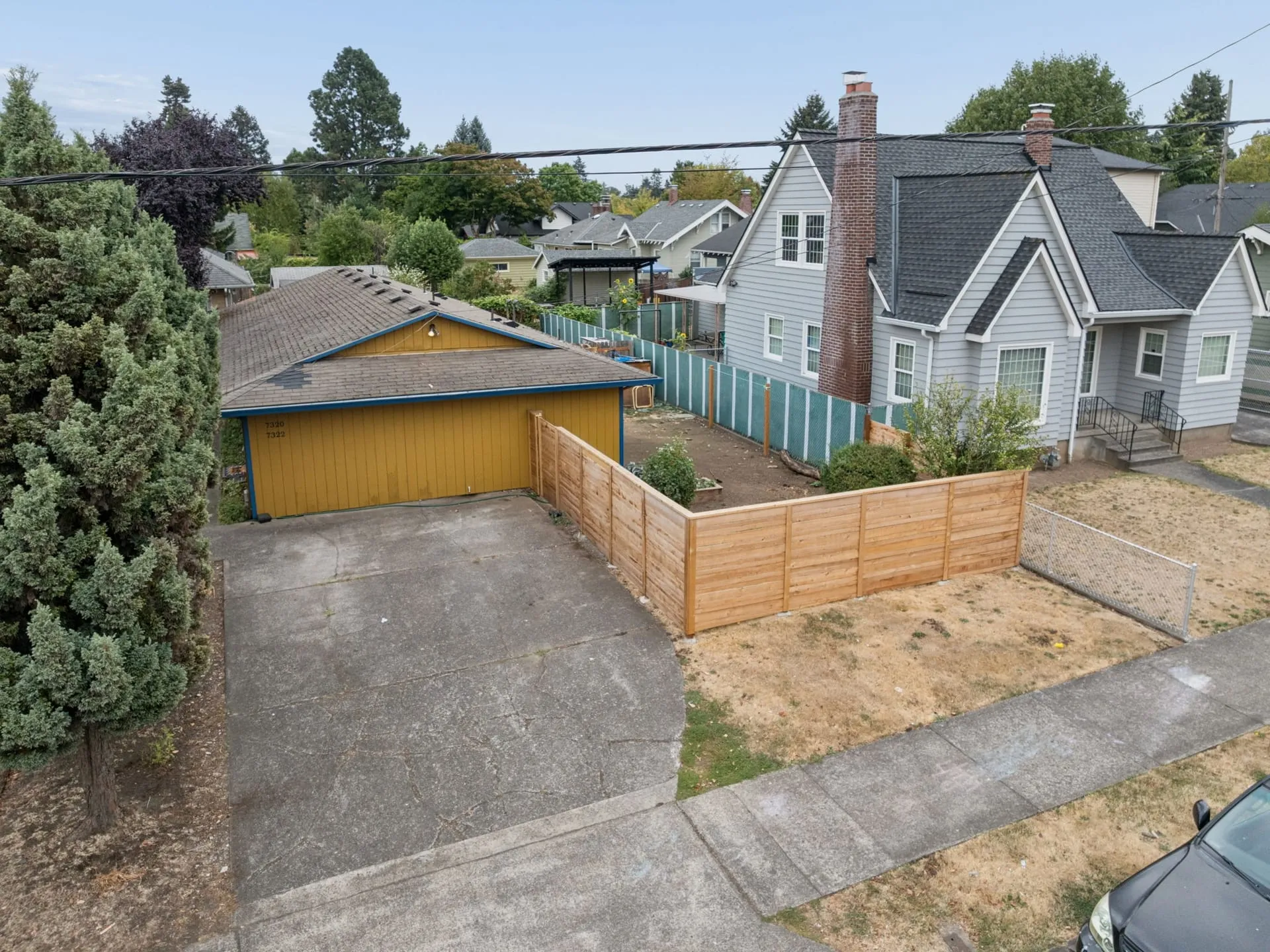 Front of the duplex with driveway and fenced yard