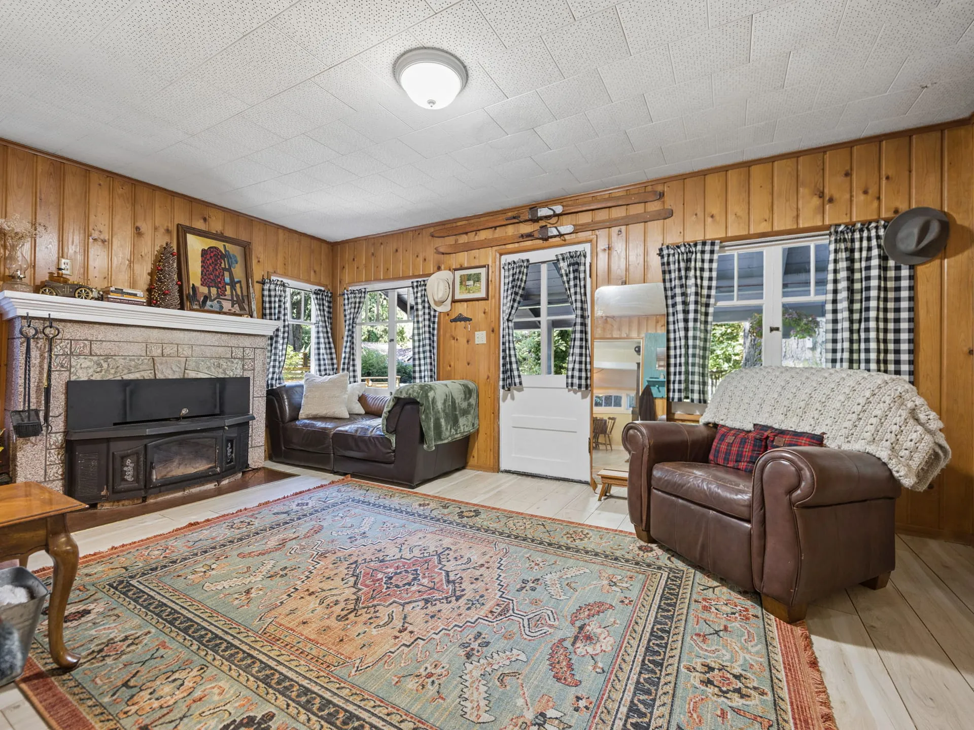 Living room with knotty pine walls and fireplace