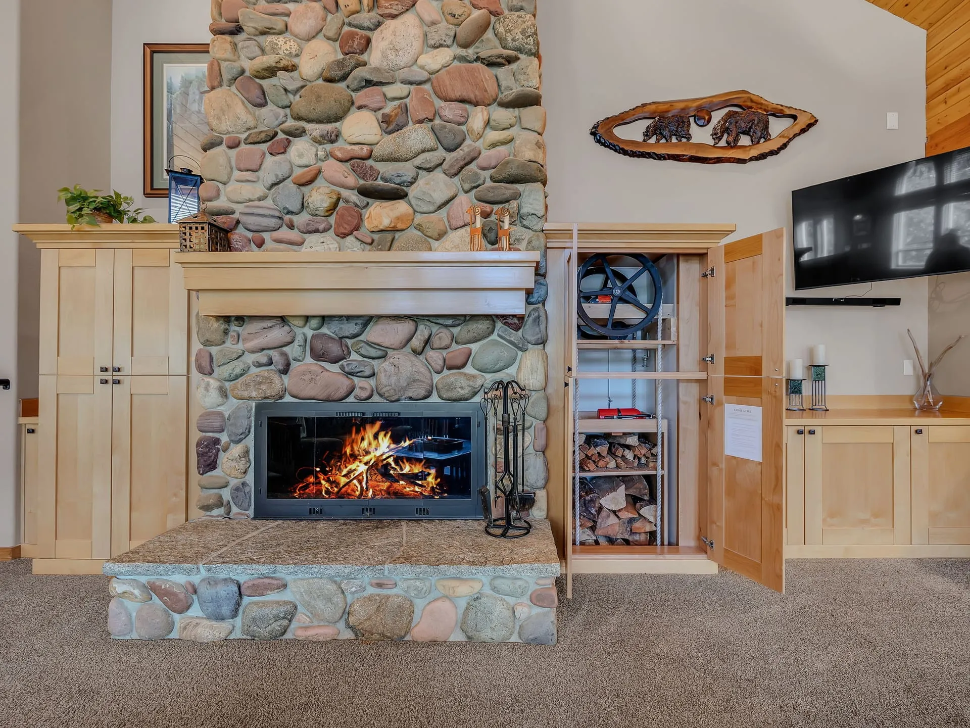 Stone fireplace with built-in cabinets and the firewood dumbwaiter