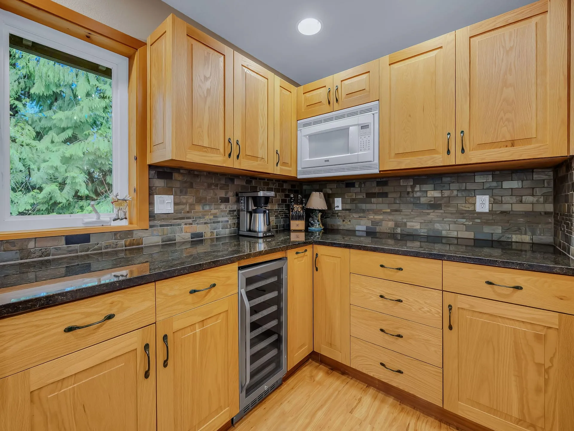 Kitchen with granite counters, tile backsplash and wine cooler